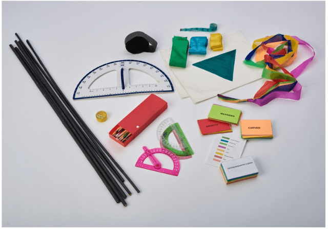 A pile of supplies for Math & Science Movers: Black Dole Rods, large protractor, ribbons, pencils, flash cards, signage, crepe paper, and tape measures.
