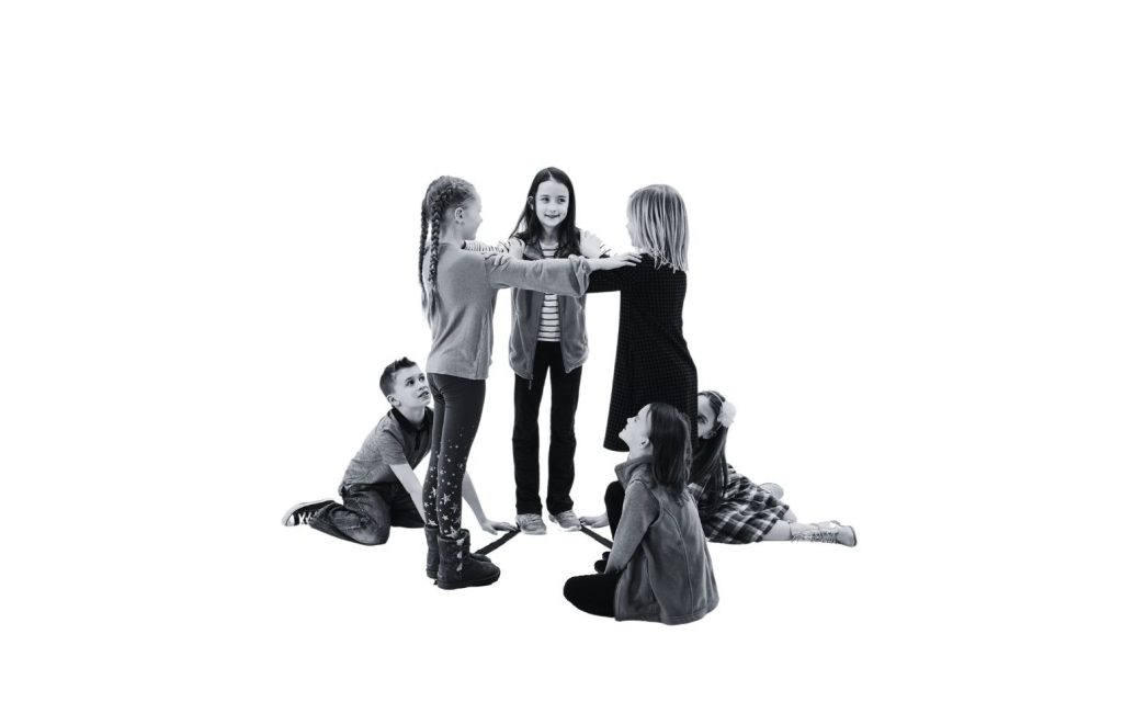 A group of young students making a triangular prism.