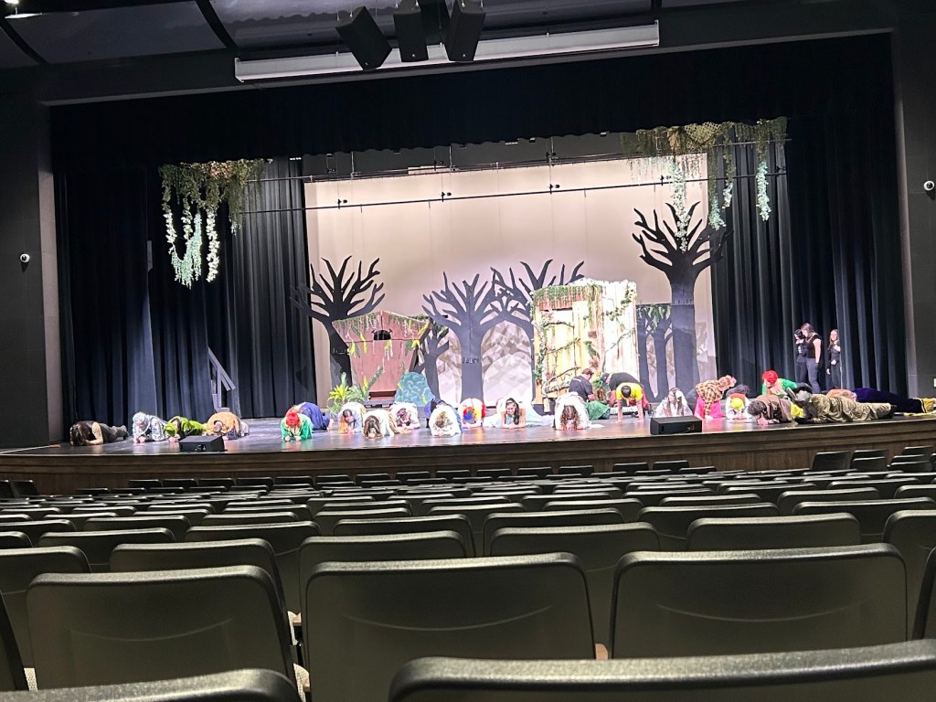 Students at Cloverleaf High School planking in their costumes to warm up before a show.
